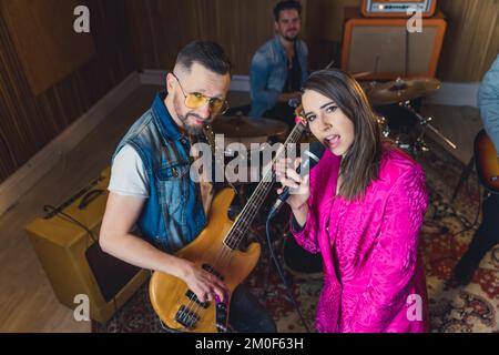 Musikband mit einer Sängerin, die eine Probe im Studio macht. Hochwertiges Foto Stockfoto