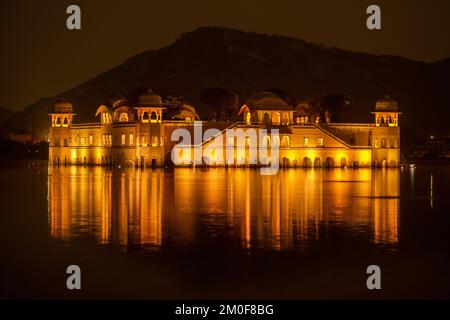 Ein malerischer Blick auf den Jal Mahal Palast in der Mitte des man Sagar Sees beleuchtet bei Nacht Stockfoto