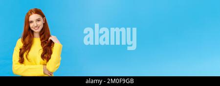 Taille-up-Shot attraktiv flirrrriger Rotkopf modernes Mädchen tausendjährige in gelbem Pullover, mit Haaren und lächelnd schön mit Unterhaltung, neugierig Stockfoto