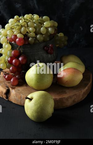 Trauben- und Birnenfrüchte auf schwarzem Hintergrund Stockfoto