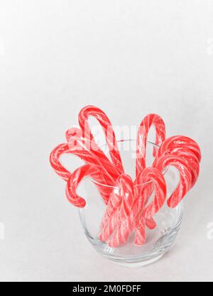 Traditionelle weihnachtliche Zuckerstangen in einem Glasgefäß mit weißem Hintergrund Stockfoto