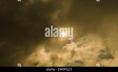 Zeitraffer goldener Wolken, die sich bei Sonnenuntergang durch den Himmel bewegen. der goldene Sonnenuntergang am Himmel im Naturhintergrund. Stockfoto