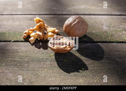 Walnüsse über einem Holzpicknicktisch. Aufnahme von natürlichem Licht Stockfoto