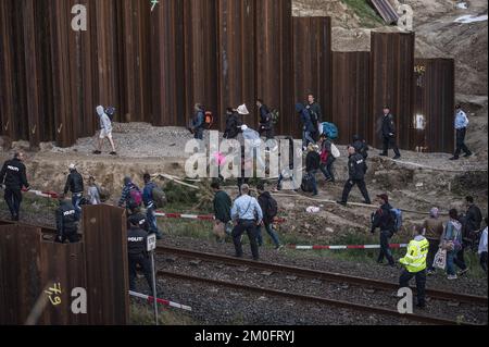 Die erste große Gruppe von Flüchtlingen und Einwanderern hat die dänische Grenze in Rødby im Süden Seelands überquert. Nach Angaben der Polizei von Süuseeland und Lolland-Falster kamen über zwei Fähren aus Puttgarden in Deutschland etwa 170 Flüchtlinge nach Rødby. Einige Migranten flohen vor der Polizei in Rødby, wurden aber angehalten und in Bussen abgeholt. Die überwiegende Mehrheit der registrierten Migranten kommt aus Syrien, und diejenigen, deren Asylverfahren in Dänemark vor Gericht gestellt werden, werden in das Flüchtlingslager Sandholmlejren entsandt. Per Rasmussen / Polfoto Flygtninge på flugt fra politiet ved Rødbyhavn. Ca Hunderrede Stockfoto