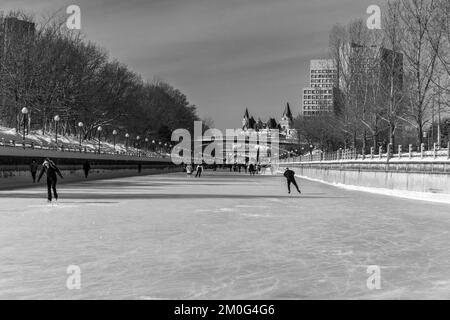 Ein Blick auf die Leute, die während Winterlude auf dem Rideau Canal mit der Skyline von Ottawa skaten Stockfoto