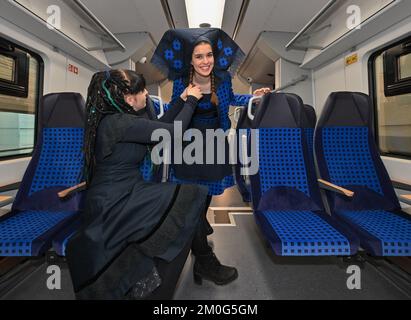 Cottbus, Deutschland. 06.. Dezember 2022. Sarah Gwiszcz (l), Modedesignerin und Model Elena Woitschehofsky präsentiert Mode aus demselben Stoff wie die Sitzbezüge im Zug im neuen Zug der Deutschen Bahn vom Typ Siemens Mireo. Am selben Tag fanden zwei Sonderreisen anlässlich der Inbetriebnahme der beiden neuen Netze der DB Regio - Netz Elbe-Spree und Netz Lausitz - statt. Dadurch verändert sich die Nahverkehrslandschaft in Berlin, Brandenburg und den angrenzenden Teilen Sachsen und Sachsen-Anhalt spürbar. Kredit: Patrick Pleul/dpa/Alamy Live News Stockfoto