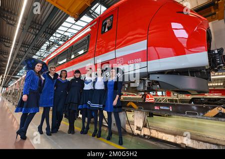 Cottbus, Deutschland. 06.. Dezember 2022. Sarah Gwiszcz (M), Modedesignerin, präsentiert die Mode mit ihren Modellen vor einem neuen Zug der Deutschen Bahn des Typs Siemens Mireo aus demselben Stoff wie die Sitzbezüge im Zug. Am selben Tag wurden zwei Sonderreisen anlässlich der Inbetriebnahme der beiden neuen DB Regio-Netze Netz Elbe-Spree und Netz Lausitz durchgeführt. Dadurch verändert sich die Nahverkehrslandschaft in Berlin, Brandenburg und den angrenzenden Teilen Sachsen und Sachsen-Anhalt spürbar. Kredit: Patrick Pleul/dpa/Alamy Live News Stockfoto