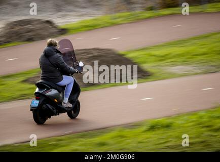 UTRECHT - Ein Mopedreiter ohne Helm. Ab dem 1. Januar 2023 ist das Tragen eines Helms auf einem leichten Moped sowohl auf Straßen- als auch Radwegen vorgeschrieben. ANP SEM VAN DER WAL niederlande raus - belgien raus Stockfoto