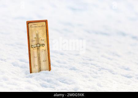 Das uralte Zierthermometer in einer weißen Schneelandschaft Stockfoto