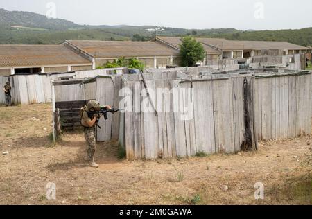 Airsoft-Spieler in offensiver taktischer Position geht auf Position. Der Sport, der deine taktischen Fähigkeiten auf die Probe stellt Stockfoto