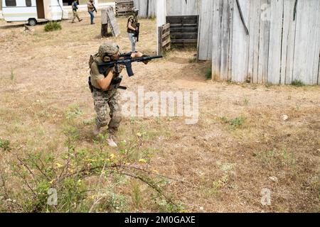 Airsoft-Spieler in offensiver taktischer Position geht auf Position. Der Sport, der deine taktischen Fähigkeiten auf die Probe stellt Stockfoto