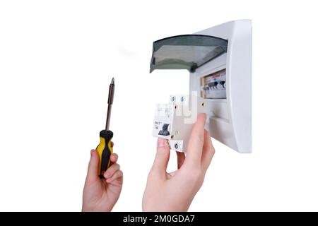 Eine Frau wechselt eine automatische Sicherung in einem elektrischen Schaltschrank, isoliert auf weißem Hintergrund. Selbstreparatur und -Austausch von elektrischen Anlagen in Stockfoto