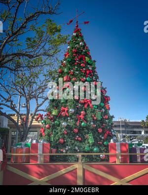 Nahaufnahme eines dekorierten Weihnachtsbaums mit großen Geschenken darunter. Stockfoto
