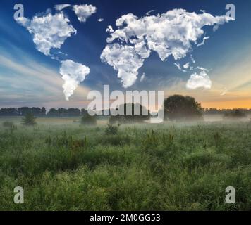 Wolken in Form einer Weltkarte über einer malerischen Wiese. Reise- und Landschaftskonzept. Frühlingswiese Stockfoto