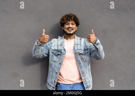 Ein junger, attraktiver araber mit isoliertem Hintergrund, der fröhliche Geste macht, mit isolierter Hand auf grauem Hintergrund Stockfoto