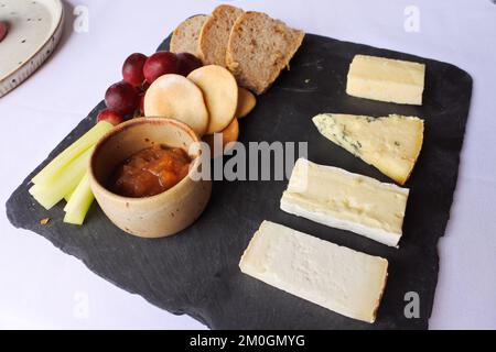 Käseplatte serviert auf einer Schiefer, Großbritannien - John Gollop Stockfoto