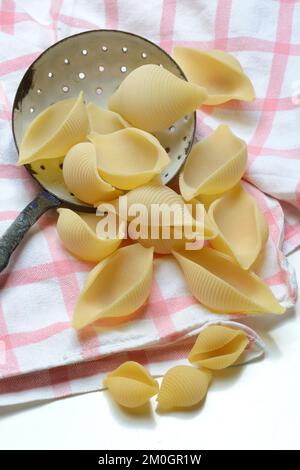 Conchiglione und kleine Conchiglie mit Siebkelle, Muschelpasta, Pasta Stockfoto