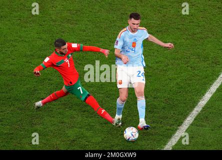 Marokkos Hakim Ziyech (links) und Spaniens Aymeric Laporte kämpfen um den Ball während des sechzehnten Spiels der FIFA-Weltmeisterschaft im Education City Stadium in Al-Rayyan, Katar. Foto: Dienstag, 6. Dezember 2022. Stockfoto