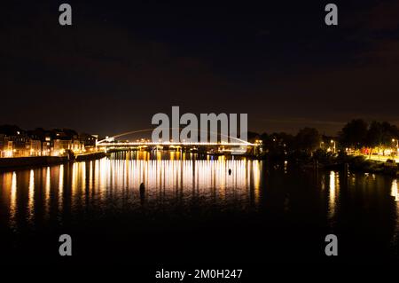 Stadtbild mit einer Brücke über die Maas im Zentrum von Maastricht bei Nacht in den Niederlanden Stockfoto