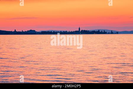 Kirche und Hafen von Romanshorn im Abendlicht, Blick von Arbon über den Bodensee Stockfoto