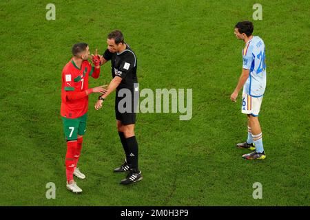Der Schiedsrichter Fernando Rapallini interveniert während des sechzehnten FIFA-Weltmeisterspiels im Education City Stadium in Al-Rayyan, Katar, zwischen Marokkos Hakim Ziyech (links) und Spaniens Pedri. Foto: Dienstag, 6. Dezember 2022. Stockfoto