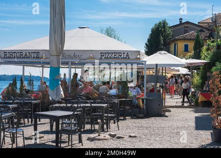 Im Sommer können Sie auf den Cafeterrassen am See im Fischerdorf Isola dei Pescatori, den Borromeo-Inseln, dem Lago Maggiore, Italien speisen Stockfoto