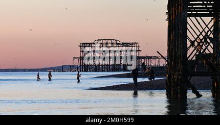 Brighton UK 6. . Dezember 2022 - Schwimmer genießen einen herrlich kühlen Sonnenuntergang am Brighton Beach , da Großbritannien in den nächsten Tagen von einer kalten Wetterwelle heimgesucht wird . : Credit Simon Dack / Alamy Live News Stockfoto