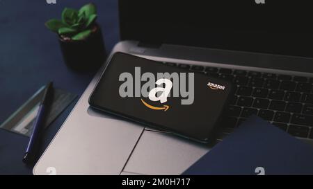 Dobrich, Bulgarien – 2022, November 26: Mobiltelefon auf einem Laptop mit Amazon-Logo und Kreditkarte im Hintergrund. Zur Illustration des Editorial Concept Stockfoto