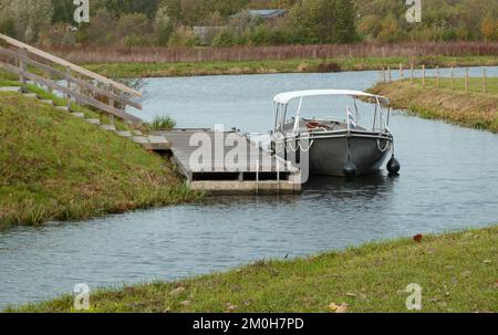 Flaches Tourboot, angelegt an einem Anleger im Fluss Vecht, Niederlande. Standort: Vechtpark, Hardenberg, Niederlande Stockfoto