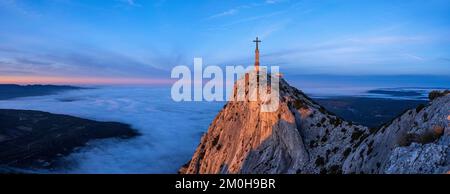 Frankreich, Bouches du Rhone, Pays d'Aix, Grand Site Sainte Victoire, Vauvenargues, Berg Sainte Victoire, Kreta, GR9, Das Kreuz der Provence (1875) (946m), im Hintergrund Aix en Provence unter einer Wolke (Luftaufnahme) Stockfoto