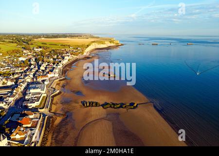 Frankreich, Calvados, Arromanches les Bains, historischer Ort der Landungen in der Normandie, Mulberry B Überreste, Port Winston, Phoenix Breakwaters, Gold Beach, Alliierte Invasion des deutsch besetzten Frankreichs bei den Landungen in der Normandie am 6. Juni 1944 und Klippen von Cap Manvieux im Hintergrund (Luftaufnahme) Stockfoto
