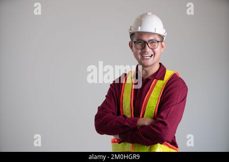 Porträt eines jungen Ingenieurs, der auf weißem Hintergrund lächelt Stockfoto