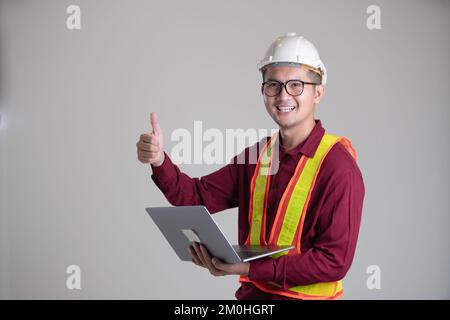 Daumen hoch für Technik und das Halten eines Laptops Stockfoto