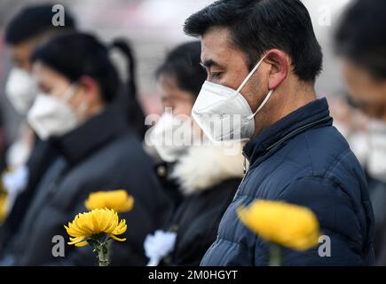 (221206) -- URUMQI, 6. Dez. 2022 (Xinhua) -- Menschen trauern um den Tod des Genossen Jiang Zemin in einer Straße in Urumqi, Nordwestchina, Autonomer Raum Xinjiang Uygur, 6. Dez. 2022. Eine Gedenksitzung für Jiang Zemin, der am 30. November im Alter von 96 Jahren verstarb, fand am Dienstagmorgen in der Großen Halle des Volkes in Peking statt. Das Treffen wurde vom Zentralkomitee der Kommunistischen Partei Chinas (CPC), dem Ständigen Komitee des Nationalen Volkskongresses (NPC), dem Staatsrat, dem Nationalen Komitee der Politischen Volkskonsultationskonferenz Chinas (CPPCC) und dem Centr abgehalten Stockfoto