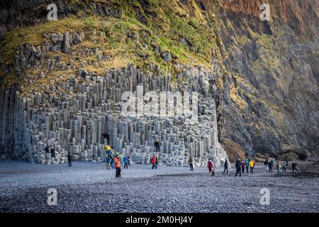 Island, Sudurland, Reynisfjara Beach, Figuren vor geometrischen Basaltsäulen am Fuße des Reynisfjall Berges, der Vik von Reynisfjara trennt Stockfoto