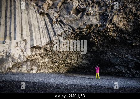 Island, Sudurland Region, Reynisfjara Strand, geometrische Basaltsäulen am Fuße des Reynisfjall Berges, der Vik von Reynisfjara trennt, Figur vor H?lsanefshellir, eine Höhle, die nur bei Ebbe zugänglich ist Stockfoto