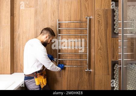 Professioneller Klempner mit Kolben und Instrumenten in der Nähe des Waschbeckens. Stockfoto
