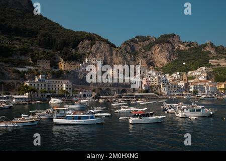 Ein allgemeiner Blick auf Amalfi Stadt von der Marina Mauer über den Hafen und die Hauptstadt mit Booten im Vordergrund und Kalksteinklippen im Hintergrund. Stockfoto