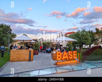 PORTO, PORTUGAL - 3. MAI 2022: Straßencafé-Basis auf dem Platz von Lissabon in Bäumen, Abend, farbenfroher Himmel, Porto, Portugal Stockfoto