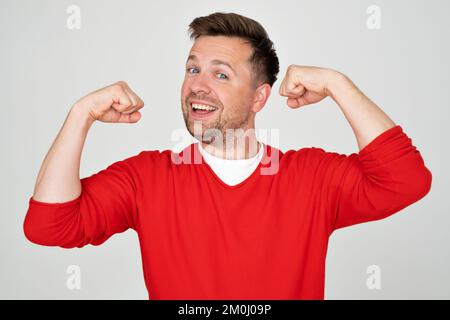 Junger, gutaussehender Mann mit Armmuskeln, selbstbewusst und stolz auf seine Macht Stockfoto