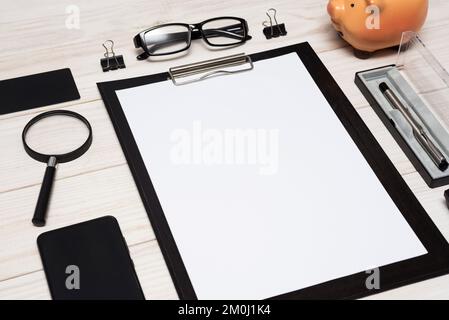 Arbeiten Sie von zu Hause aus. Arbeitsplatz mit Smartphone, Stift, Brille, Taschenrechner Stockfoto