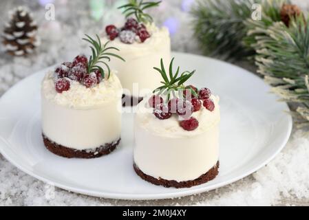 Mousse Cakes mit Kokosnusscreme und griechischer Joghurt über Schokoladenkuchen sind das perfekte Dessert. Gib Schlagsahne und Beeren hinzu. Verwöhnen Sie Freunde und Angehörige Stockfoto