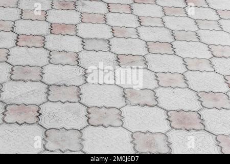 Graue Pflasterplatten städtischer Boden mit geometrischem Fliesenmuster als Straßenhintergrund der Stadt. Stockfoto