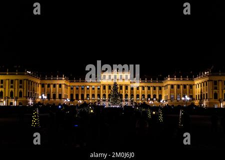 Stadtbild des Schlosses Schönbrunn in Wien bei Nacht. Traditionelles Panorama des Weihnachtsmarkts auf der Burg Sissi in Wien. Stockfoto