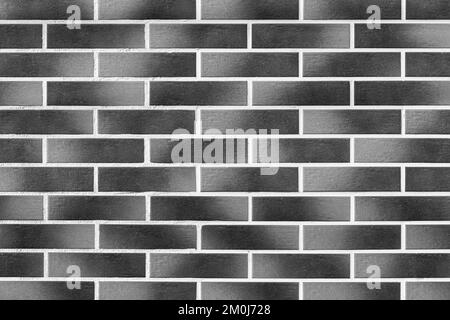 Dunkelgrau schwarz-weiß, moderne Backsteinfassade, Außenwand, Texturhintergrund. Stockfoto