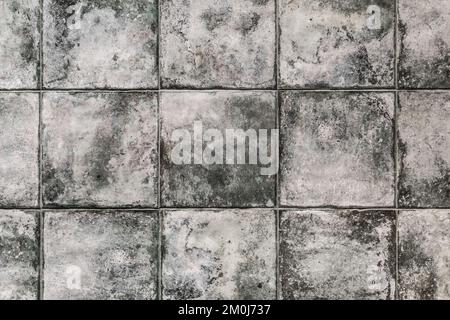 Graue, schmutzige Mosaikfliesen aus Keramik mit abstraktem Muster und Texturhintergrund in modernem Interieur. Stockfoto