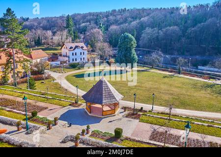 Die wunderschönen grünen Breuer Gardens mit hohen Pinien, hölzernen Pavillons, Blumenbeeten, Brücke über den Vrchlice Creek und Wald im Hintergrund, Kutna Hora, C. Stockfoto