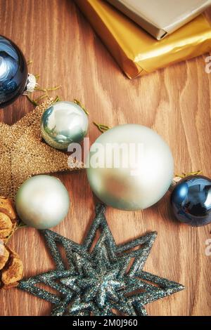 Weihnachtsspielzeug und Geschenkschachteln, die auf dem Holztisch verstreut sind. Vorlage für vertikales Neujahrsmodell Stockfoto