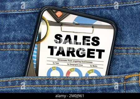 Geschäfts- und Finanzkonzept. In einer Jeanentasche befindet sich ein Smartphone auf dem Bildschirm, dessen Text - VERKAUFSZIEL Stockfoto