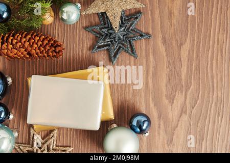 Weihnachtskomposition mit blauen Spielzeugbällen, Schneeflocken und Hütchen. Geschenkschachteln und Geschenke in der Nähe des Brunch mit grünen Tannen Stockfoto